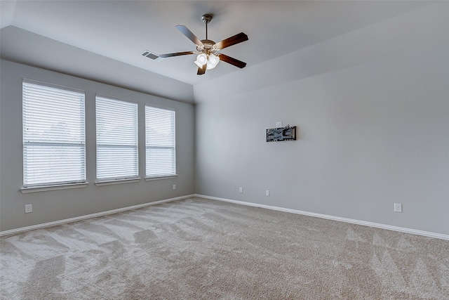 carpeted empty room featuring lofted ceiling, plenty of natural light, visible vents, and ceiling fan