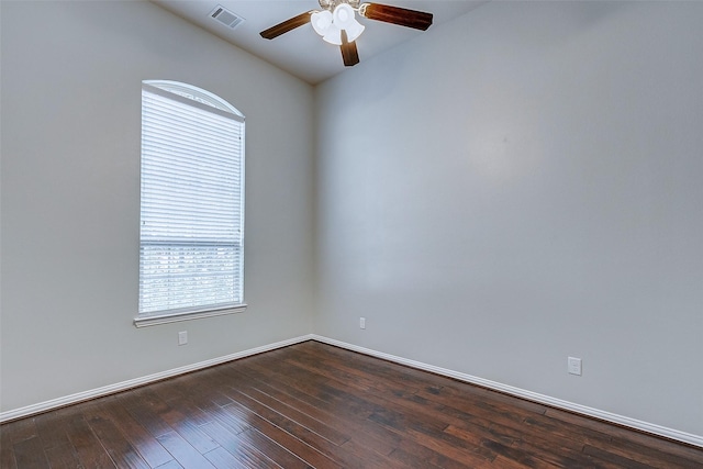 spare room featuring visible vents, baseboards, dark wood-type flooring, and ceiling fan