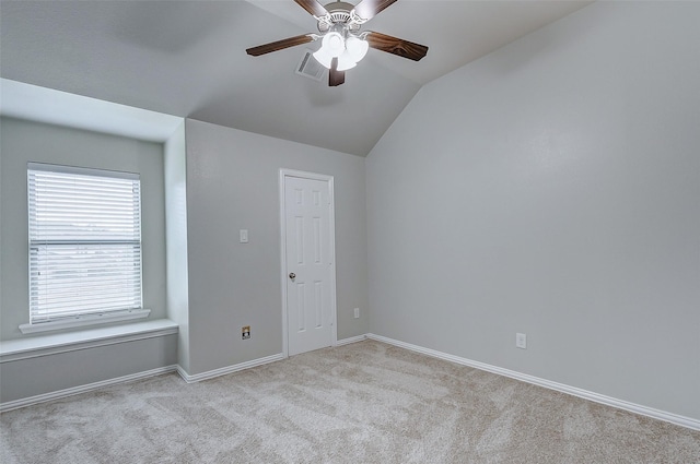 carpeted spare room featuring visible vents, lofted ceiling, baseboards, and ceiling fan