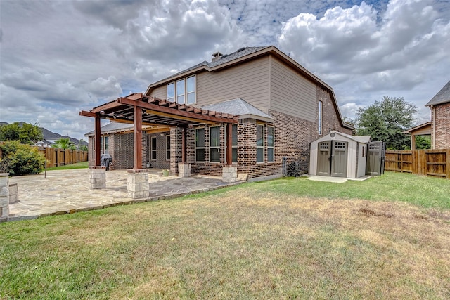 back of house with brick siding, a fenced backyard, a patio area, a storage unit, and an outbuilding