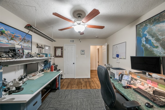 office space with a textured ceiling, dark wood-type flooring, and ceiling fan