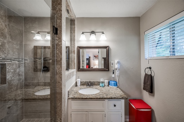 bathroom featuring a shower with shower door and vanity