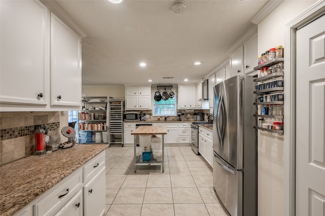 kitchen with white cabinetry, tasteful backsplash, light tile patterned floors, sink, and appliances with stainless steel finishes