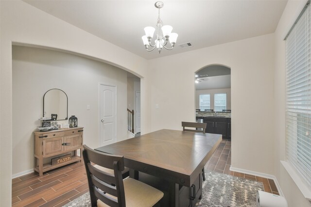 dining area with dark hardwood / wood-style flooring, sink, and a notable chandelier