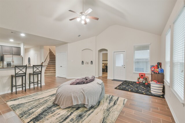 living room with light wood-type flooring, vaulted ceiling, and ceiling fan