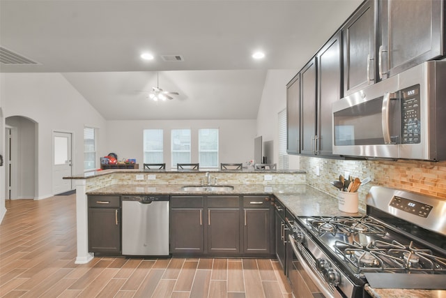 kitchen featuring appliances with stainless steel finishes, ceiling fan, kitchen peninsula, and vaulted ceiling