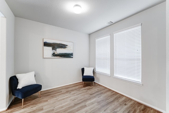 unfurnished room featuring light wood-type flooring and a textured ceiling