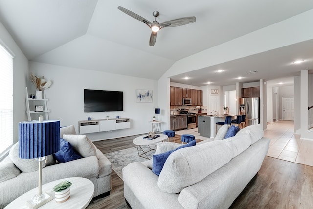 living room featuring lofted ceiling, ceiling fan, and wood-type flooring