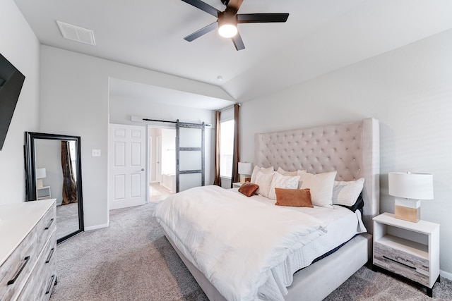 bedroom featuring a barn door, ceiling fan, carpet floors, and vaulted ceiling