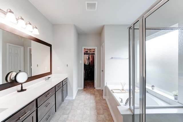 bathroom featuring vanity and independent shower and bath