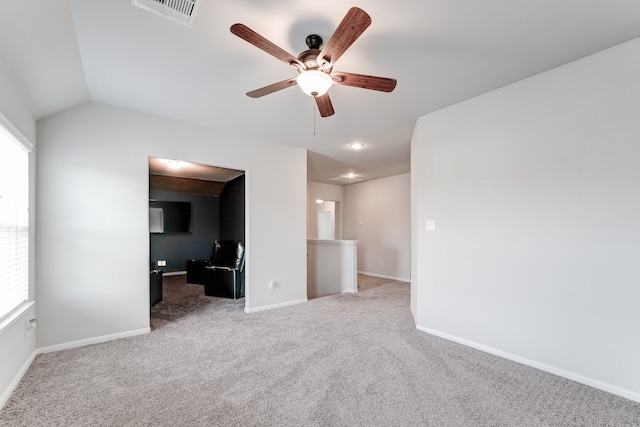 carpeted spare room featuring ceiling fan, plenty of natural light, and vaulted ceiling