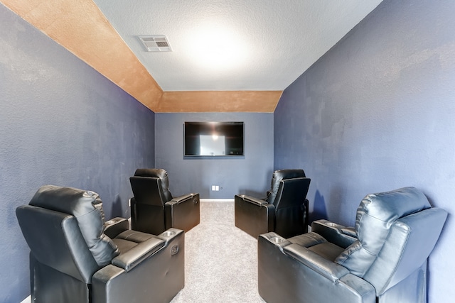 home theater with vaulted ceiling, carpet floors, and a textured ceiling