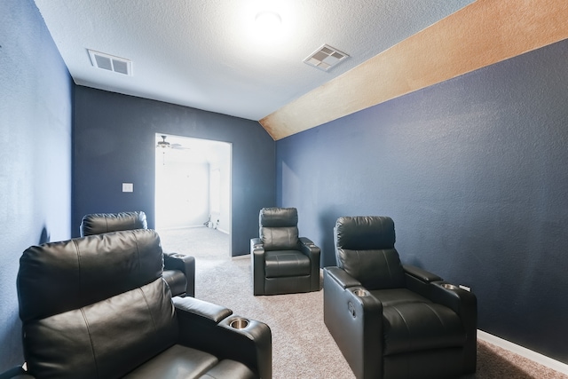 home theater with lofted ceiling, a textured ceiling, and carpet