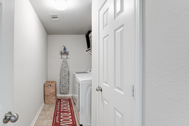 laundry room with independent washer and dryer and a textured ceiling