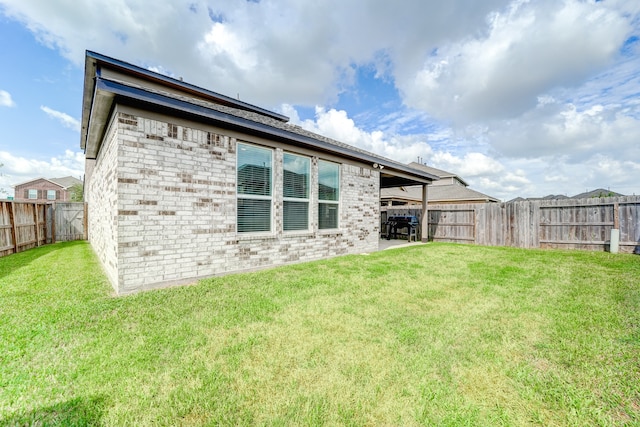 back of property featuring a lawn and a patio