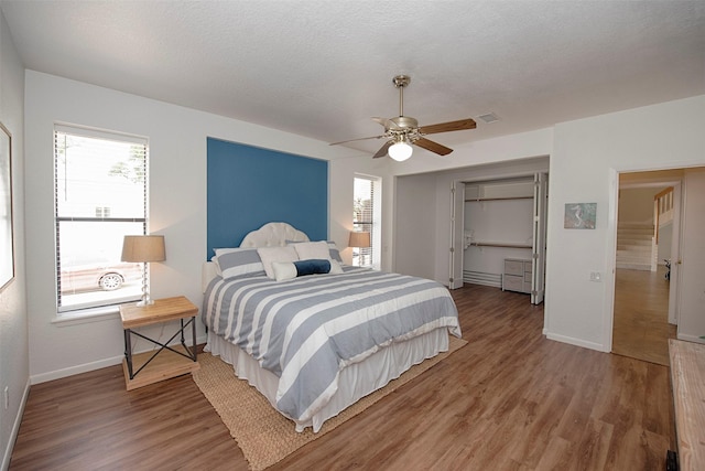 3821 Nasa Rd Unit 1, Seabrook, TX 77586 - bedroom featuring multiple windows, light wood-style flooring, and ceiling fan