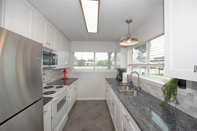 3821 Nasa Rd Unit 1, Seabrook, TX 77586 - kitchen featuring stainless steel appliances, decorative backsplash, dark tile patterned floors, and white cabinets