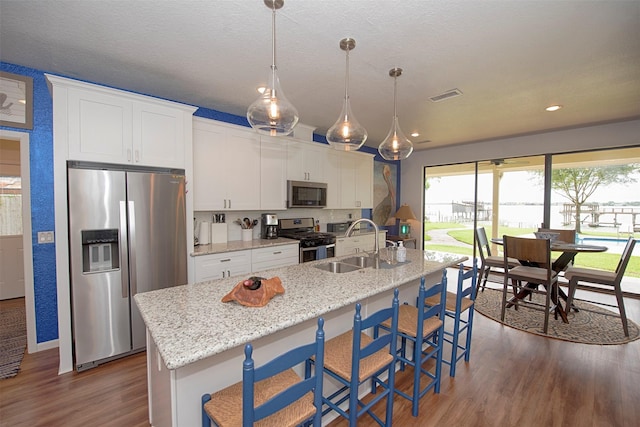 3821 Nasa Rd Unit 1, Seabrook, TX 77586 - kitchen featuring stainless steel appliances, dark wood finished floors, a center island with sink, white cabinetry, and recessed lighting
