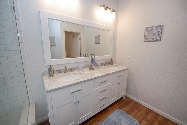 3821 Nasa Rd Unit 1, Seabrook, TX 77586 - full bathroom featuring double vanity, wood finished floors, tiled shower, and a textured wall