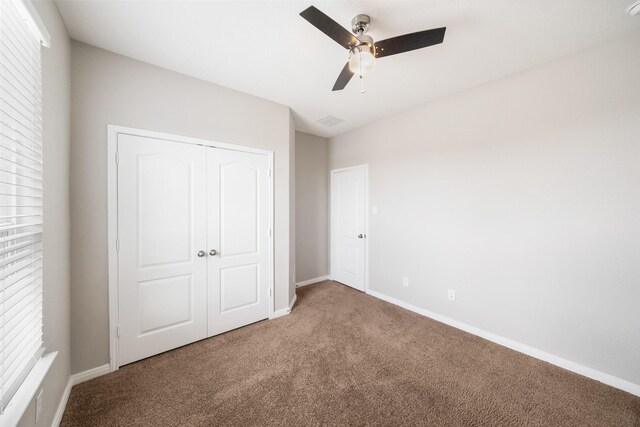 unfurnished bedroom featuring carpet, ceiling fan, and a closet