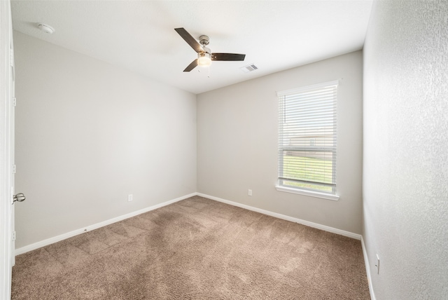 spare room featuring ceiling fan and carpet floors