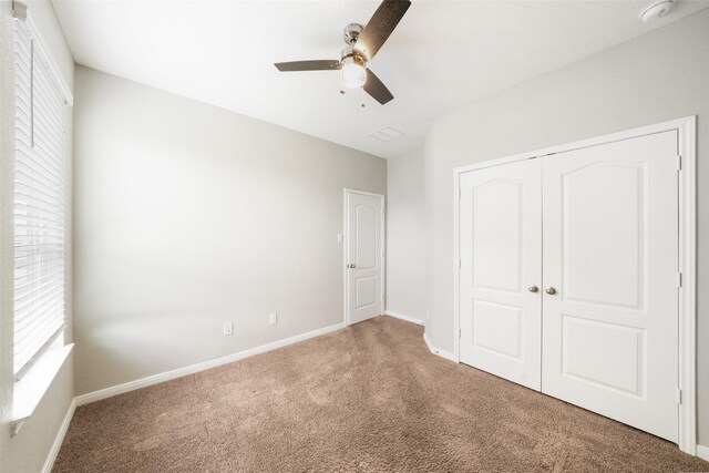 unfurnished bedroom featuring ceiling fan, a closet, and carpet floors