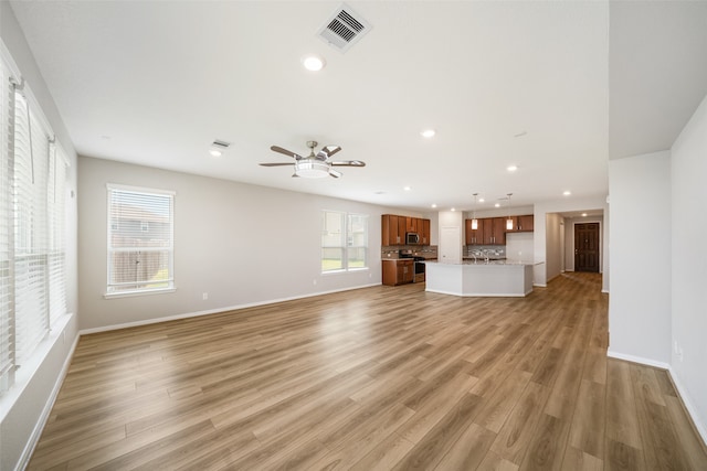 unfurnished living room featuring light wood-type flooring and ceiling fan