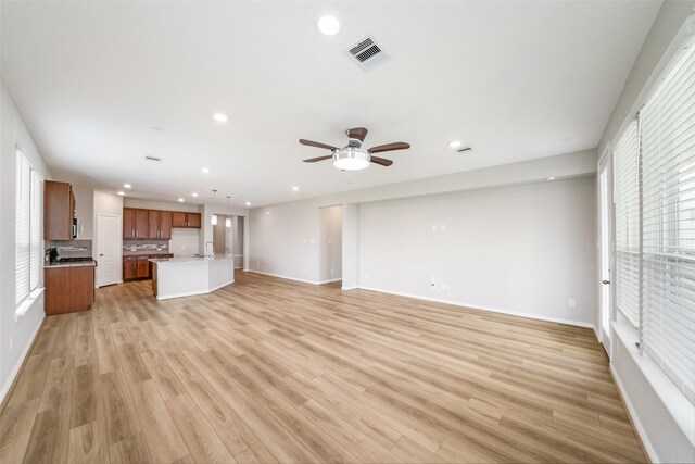 unfurnished living room with ceiling fan and light hardwood / wood-style floors