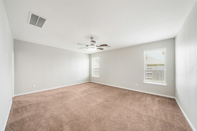 carpeted spare room with ceiling fan