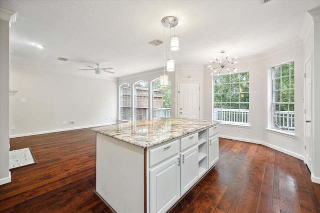 kitchen with a wealth of natural light, a kitchen island, and dark wood-type flooring