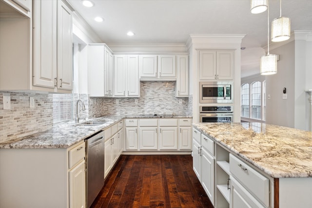 kitchen featuring white cabinets, appliances with stainless steel finishes, dark hardwood / wood-style floors, pendant lighting, and sink