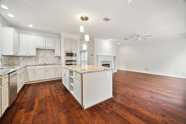 kitchen with a center island, appliances with stainless steel finishes, dark hardwood / wood-style floors, and white cabinetry