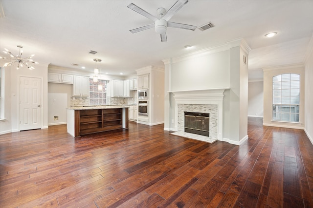 unfurnished living room with ornamental molding, dark hardwood / wood-style floors, and ceiling fan with notable chandelier