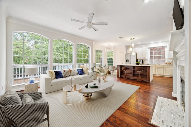 sunroom / solarium with a healthy amount of sunlight and ceiling fan with notable chandelier