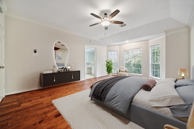 bedroom with ornamental molding, ensuite bathroom, dark wood-type flooring, and ceiling fan