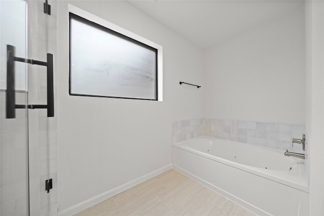 bathroom with a tub to relax in and tile patterned flooring