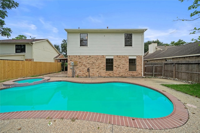 view of swimming pool with an in ground hot tub