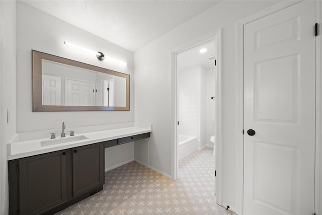 bathroom with vanity, a textured ceiling, and toilet