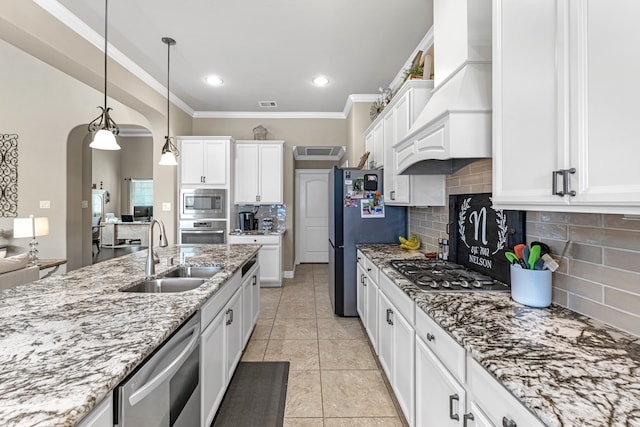 kitchen featuring sink, decorative light fixtures, white cabinetry, stainless steel appliances, and custom range hood