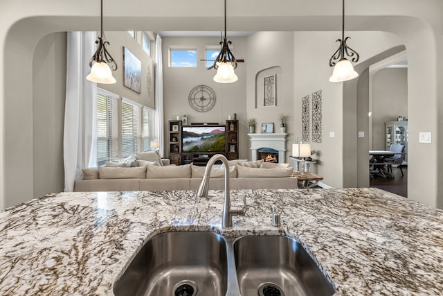 kitchen featuring hanging light fixtures, light stone countertops, and hardwood / wood-style flooring