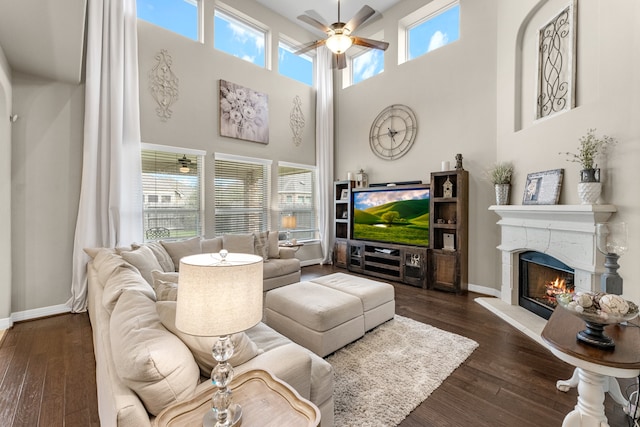 living room with a wealth of natural light, ceiling fan, and dark hardwood / wood-style flooring