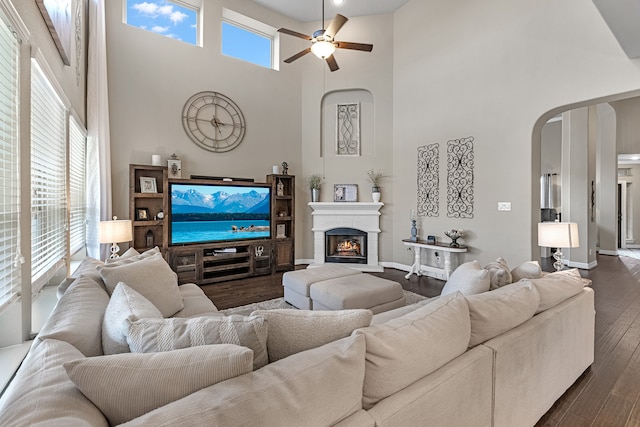 living room with a healthy amount of sunlight, a towering ceiling, and ceiling fan