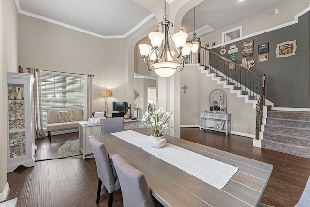 dining space featuring a notable chandelier, crown molding, and dark hardwood / wood-style flooring