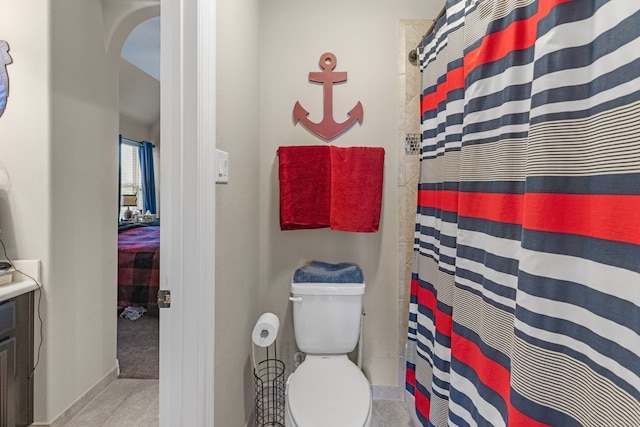 bathroom with a shower with shower curtain, tile patterned floors, and toilet