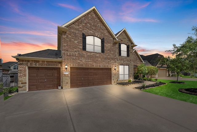 view of front of property with a garage and a lawn