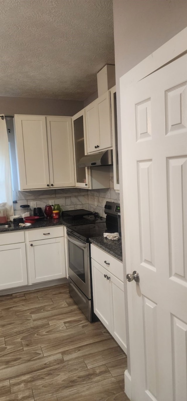 kitchen with white cabinetry, hardwood / wood-style flooring, electric stove, and a textured ceiling