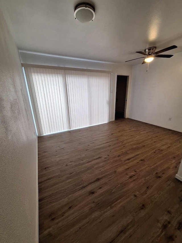 empty room with dark wood-type flooring and ceiling fan