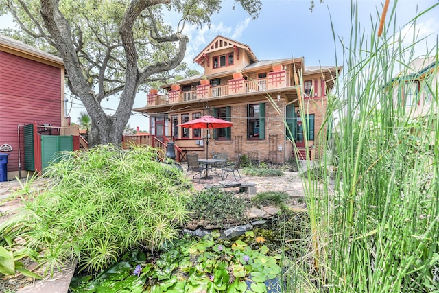 rear view of property featuring a patio and a balcony