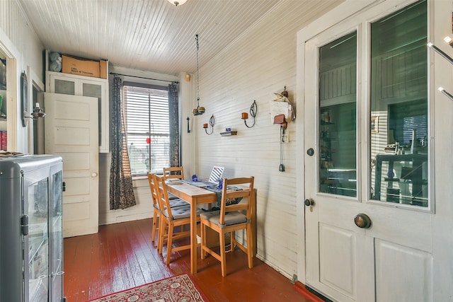 dining space featuring washer / dryer, wood walls, and dark hardwood / wood-style floors