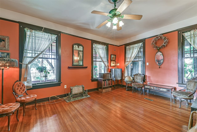 misc room with plenty of natural light, wood-type flooring, and ceiling fan